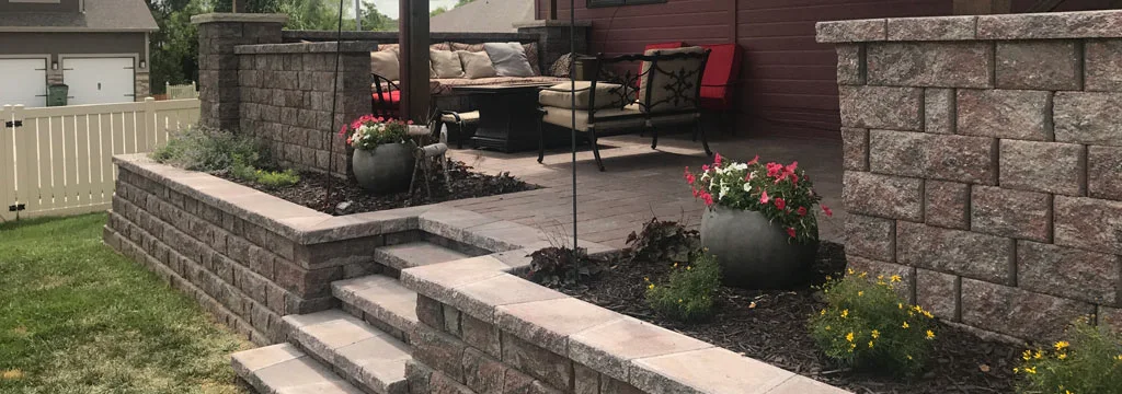 Retaining wall with plantings and mulch installed in Omaha, NE.